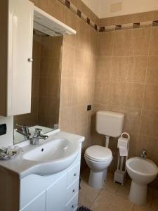 ein Badezimmer mit einem weißen Waschbecken und einem WC in der Unterkunft Appartamento per le vacanze ,, Villa Miky,, in Pairola
