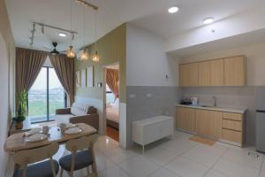 cocina y sala de estar con mesa y sillas en 5 Pax The Glenz New Cozy Homestay, en Batu Gugup