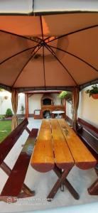 a large wooden table with a large umbrella at Casa Bianca si Andrei in 2 Mai
