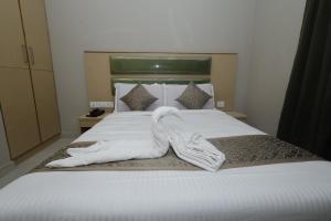 Postel nebo postele na pokoji v ubytování Grand Courtyard Business Hotel