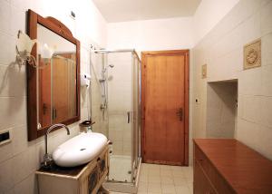bagno con lavandino e doccia con specchio di COUNTRY HOUSE a Sezze