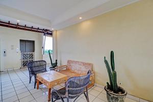 a dining room with a table and chairs and a cactus at Guest House Simalem in Legian