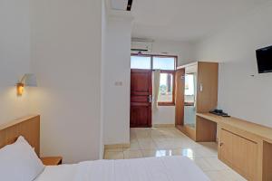 um quarto de hotel com uma cama e uma cozinha em Guest House Simalem em Legian