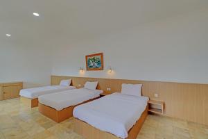 um quarto com duas camas num quarto em Guest House Simalem em Legian