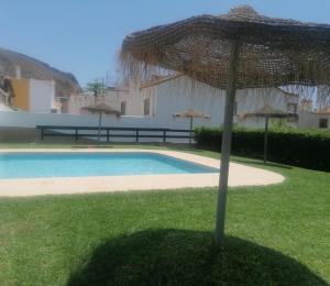 una sombrilla en el césped junto a una piscina en Casa Rosita Relax - Piscina y gran terraza, en Aguadulce