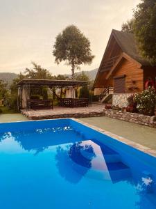 a blue swimming pool in front of a house at Blue Village Lux in Kolašin