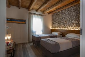a hotel room with two beds and a window at Il Re Della Cantina - Locazione Turistica in Crocetta del Montello