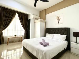 Un dormitorio con una cama con un par de zapatillas. en 3BR Mount Austin @Midori Green (1 to 8pax), en Johor Bahru