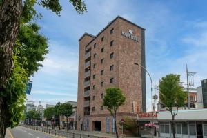 a tall brick building on a city street at Jecheon Hound Hotel in Jecheon