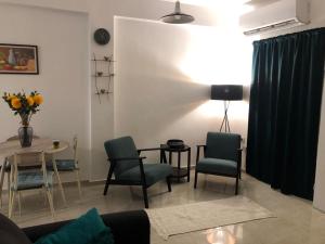 ein Wohnzimmer mit einem Tisch und Stühlen in der Unterkunft Good Place in Netanya