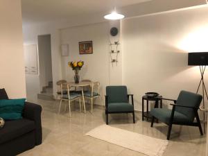 ein Wohnzimmer mit einem Sofa, Stühlen und einem Tisch in der Unterkunft Good Place in Netanya