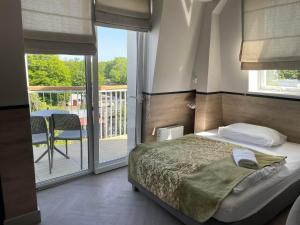 ein Schlafzimmer mit einem Bett und einem Balkon in der Unterkunft Promień Słońca in Świnoujście
