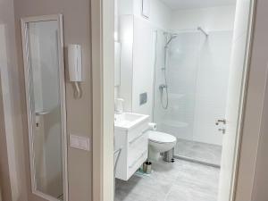 a white bathroom with a shower and a toilet at Aqua Apartman in Zalakaros +24 photos