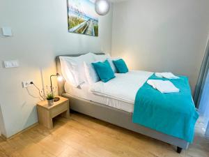 a small bedroom with a bed with blue pillows at Aqua Apartman in Zalakaros
