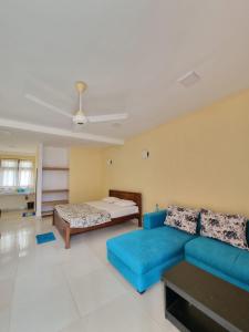 a living room with a blue couch and a bed at Thalalla Ocean View in Dickwella