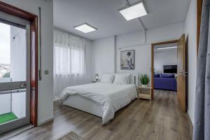 a white bedroom with a bed and a mirror at Travel & Live Fernão Magalhães in Porto