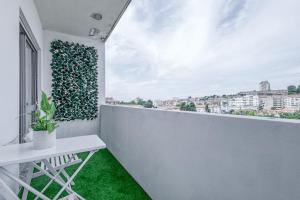 a white balcony with a green plant on the wall at Travel & Live Fernão Magalhães in Porto