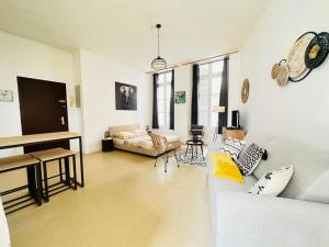 a living room with a couch and a piano at Appartement confortable in Laon