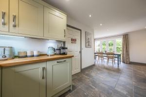 a kitchen with white cabinets and a dining room at Sherborne House in Wells next the Sea