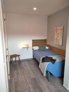 ein Schlafzimmer mit einem Bett und einem Tisch darin in der Unterkunft Apartamentos Turísticos Tenor by Bossh Hotels in Barcelona