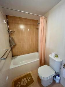 a bathroom with a toilet and a tub and a shower at Playa grande Miño travesía in Miño