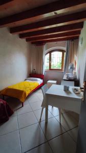 a bedroom with a yellow bed and a table at Albergo Le Piante in Manerba del Garda