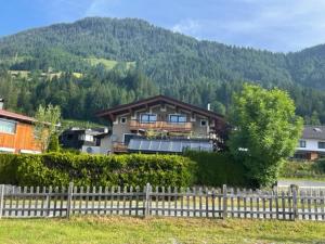 una casa con una valla delante de una montaña en Ferienwohnung Wieser, en Sankt Jakob in Haus