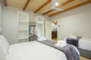 een slaapkamer met 2 bedden en witte handdoeken bij Kruger Wild Dog Inn in Marloth Park