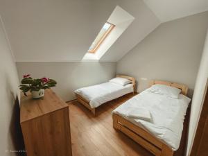 a bedroom with two beds and a table and a window at Apartamenty Grey in Okuninka