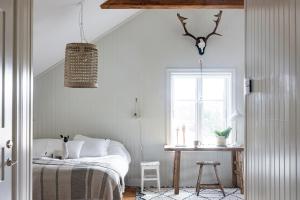 um quarto com uma cama, uma mesa e uma janela em Siggesta Gård em Värmdö