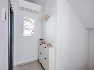 een witte hal met een raam en een dressoir bij Luxury villa with private pool and 7 bedrooms in Torrox