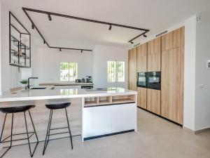 een keuken met witte werkbladen en houten kasten bij Luxury villa with private pool and 7 bedrooms in Torrox