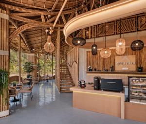 een restaurant met een bar en tafels en hanglampen bij ภูคานาน่าน รีสอร์ท 