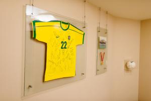 a yellowttenham shirt hanging on a wall at Hotel Crystal in Londrina