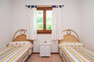 two twin beds in a room with a window at Amazing Seaview house in Tamariu in Girona +19 photos