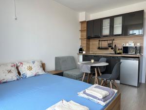 1 Schlafzimmer mit einem blauen Bett und einer Küche in der Unterkunft Ив-Бо in Rawda