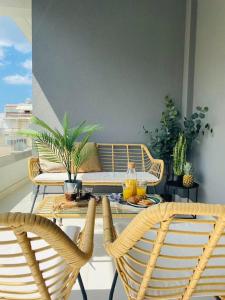 a patio with a table and chairs on a balcony at NEW 2BD Apt with Shared Rooftop Pool in Athens