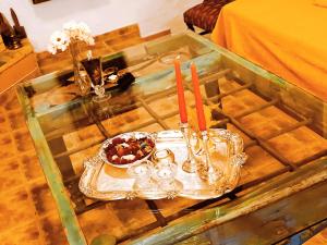 a glass table with a tray with candles on it at Villa 5 Anemoi in Lefkogeia