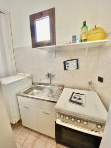 a small kitchen with a sink and a stove at Salento Soleluna in Matino