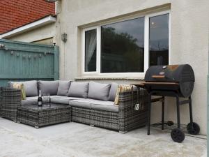 a grill sitting next to a couch and a grill at Pass the Keys New Cosy 2 Bed Flat with garden nr Beach Sleeps4 in South Hayling