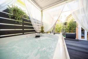 a jacuzzi tub in a room with a window at Sea Garden Apartments & Rooms in Grado
