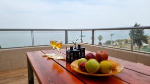 een tafel met een schaal fruit en glazen wijn bij Galilee Triple Terrace in Tiberias