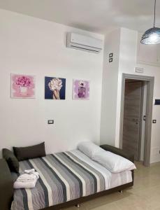 ein Schlafzimmer mit einem Bett mit einer gestreiften Decke in der Unterkunft L'atelier - Locazione turistica in Scilla