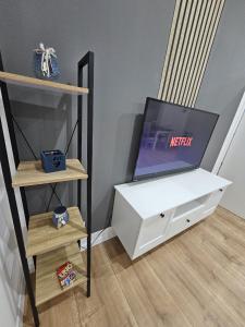 a living room with a tv and a white dresser at Küstenzauber - Balkon - Tolle Lage - Netflix in Wilhelmshaven +25 photos