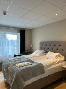 - une chambre avec un grand lit et une fenêtre dans l'établissement Hotell Solstickan, à Mellbystrand