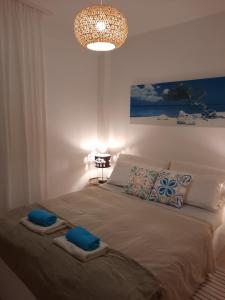 Schlafzimmer mit einem Bett mit blauen Kissen und einem Kronleuchter in der Unterkunft Apartamento del Azahar in Playa de Gandia