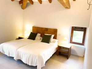 a bedroom with a large white bed and a window at Casona Molinos del Agua in Arnuero