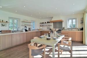uma cozinha com uma mesa e cadeiras numa cozinha em Le Verger - Charmante maison avec jardin em Saint-Lunaire