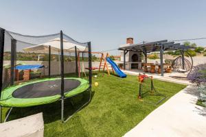 a playground with a trampoline on the grass at Vila Katarina ZadarVillas in Tinj