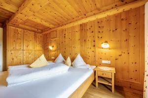 ein Schlafzimmer mit einem Bett in einem Holzzimmer in der Unterkunft Mitterbruggehof Apt Enzian in Anterselva di Mezzo